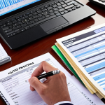 **Auction Preparation**: Create an image of a person sitting at a desk with auction documents spread out, looking focused and taking notes. Include elements like a computer showing an online auction platform and a notepad with budgeting strategies written down.